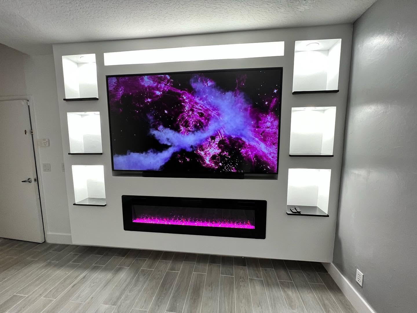Entertainment center with lit display niches, floating shelves and a linear fireplace.