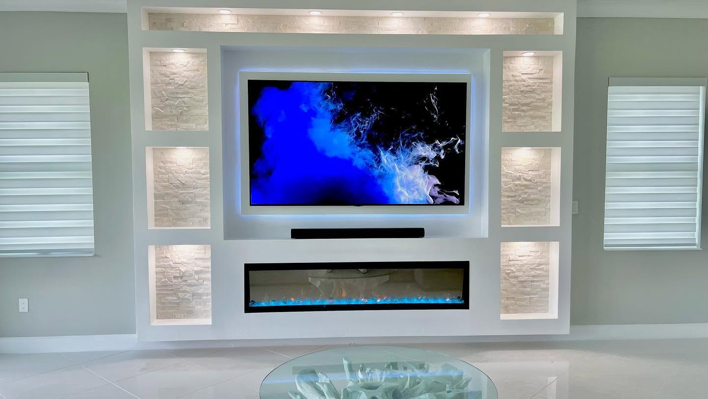 The same feature wall finished, with stacked-stone lit niches and a linear fireplace.