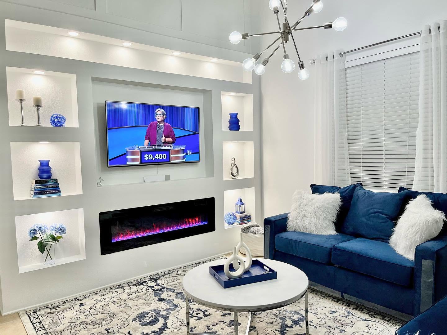 Finished living room with a lit-niche media wall and furnished seating.