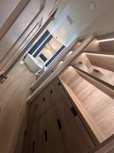 Angled wood slat panelling carried from the wall across a ceiling detail.