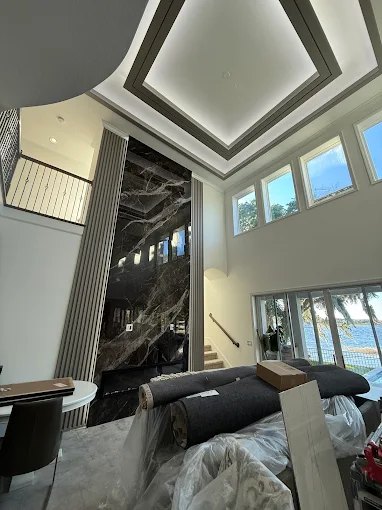 Double-height marble feature wall running the full height of a two-story living space.