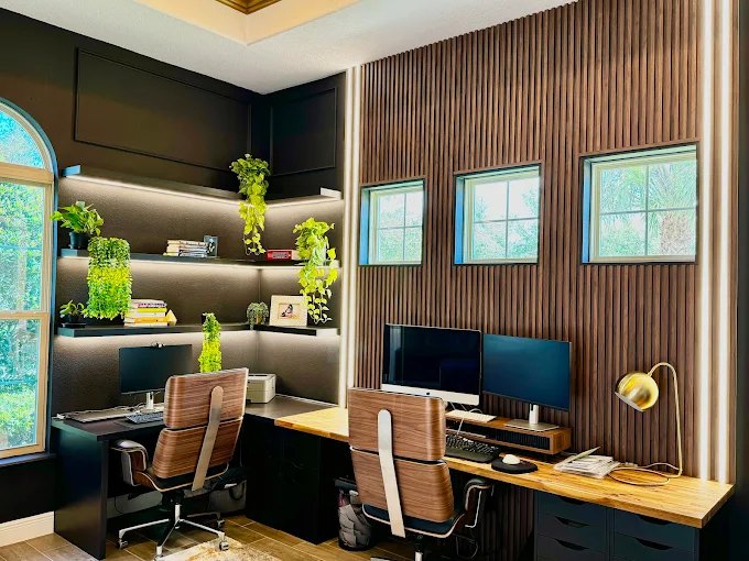 Home office with a wood slat feature wall, twin built-in desks, open shelving and integrated lighting.
